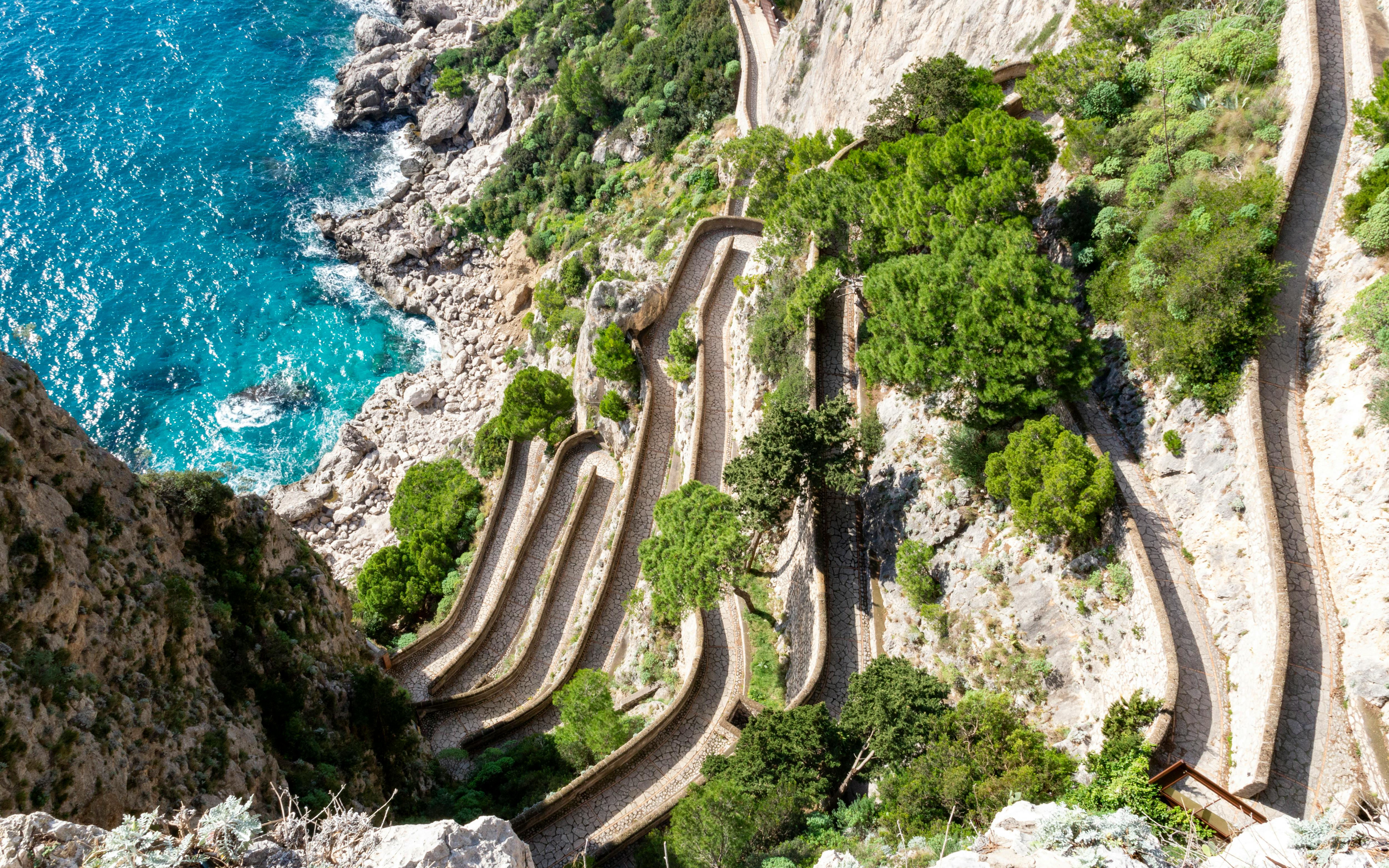 Via Krupp switchback path on Capri, Italy, with coastal cliffs and turquoise sea.