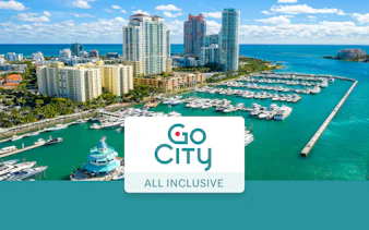 Drone view of Miami Beach marina with yachts and high-rise buildings.