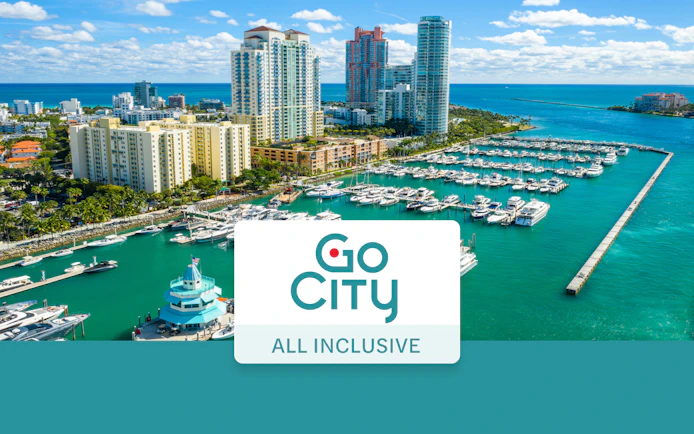 Drone view of Miami Beach marina with yachts and high-rise buildings.