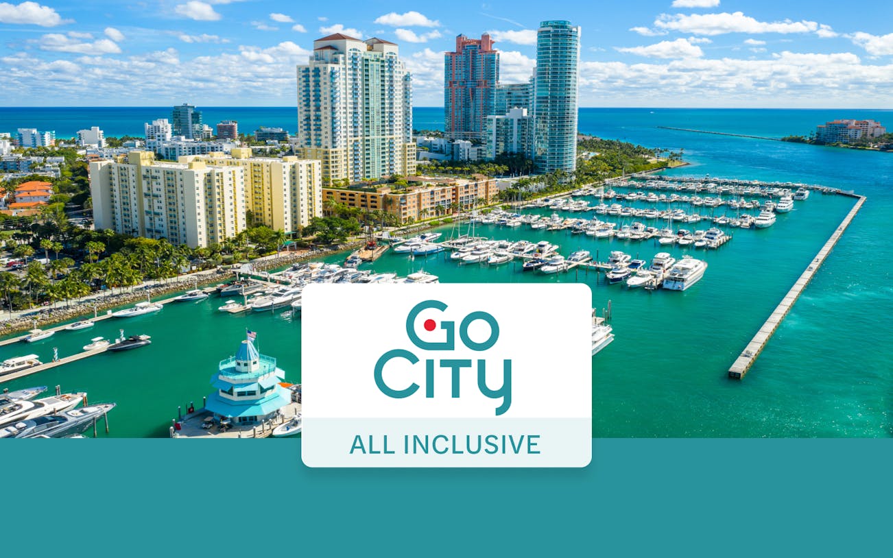 Drone view of Miami Beach marina with yachts and high-rise buildings.