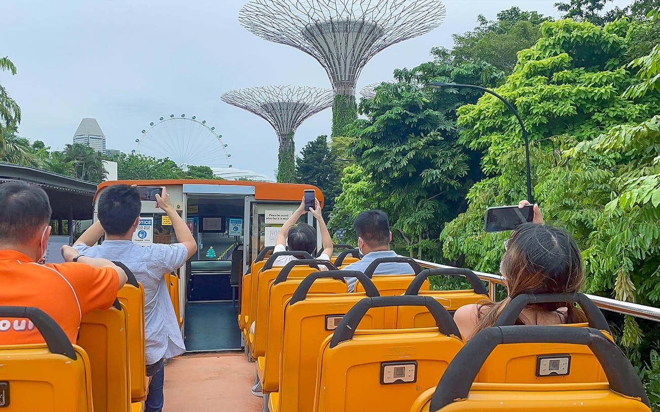 People on FunVee tour bus capturing Supertree Grove and Singapore Flyer.