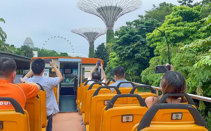 People on FunVee tour bus capturing Supertree Grove and Singapore Flyer.