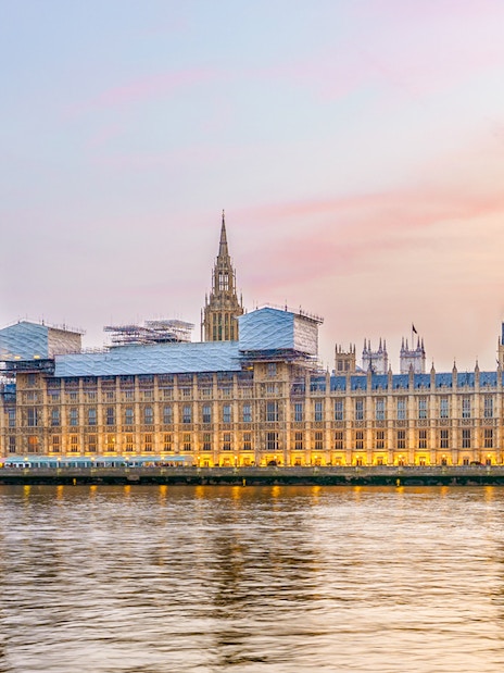 Houses of Parliament viewed from the Thames River at sunset.