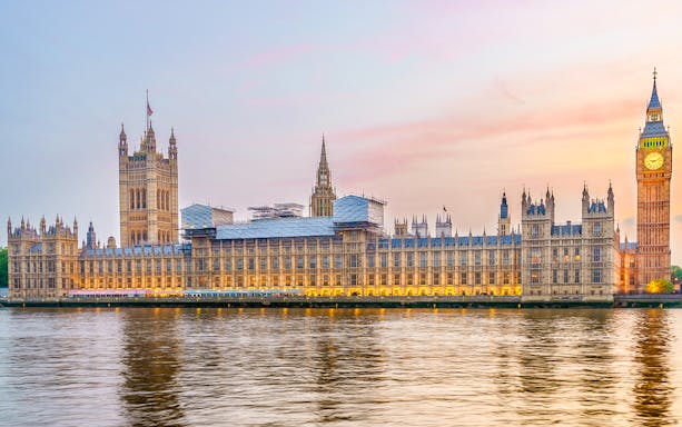 Houses of Parliament viewed from the Thames River at sunset.
