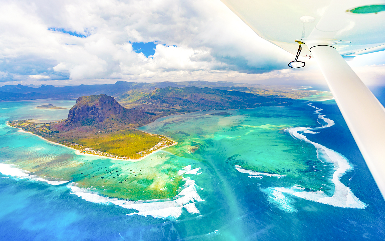Aerial view of Le Morne Brabant and turquoise waters during a seaplane tour, Mauritius.