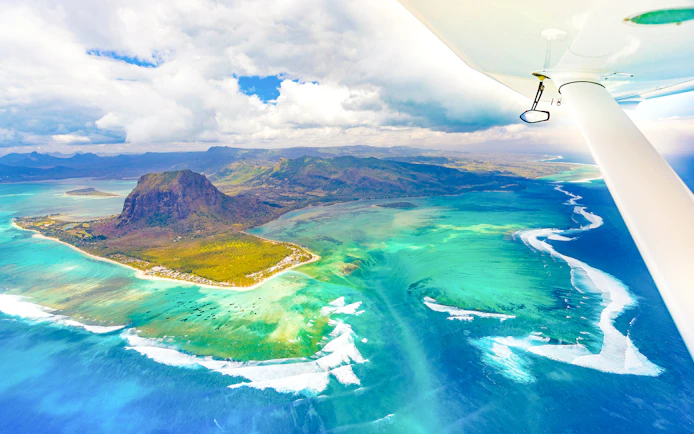 Aerial view of Le Morne Brabant and turquoise waters during a seaplane tour, Mauritius.