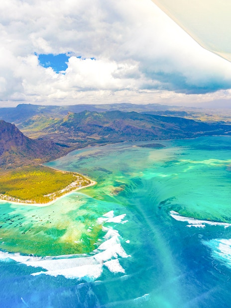 Aerial view of Le Morne Brabant and turquoise waters during a seaplane tour, Mauritius.