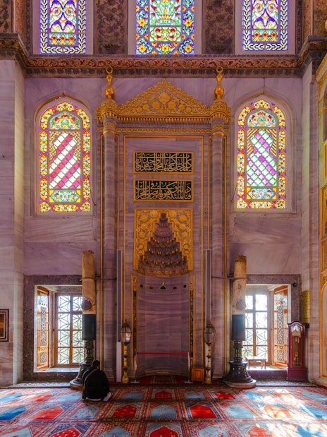 Stained glass windows and ornate mihrab inside the Blue Mosque, Istanbul.