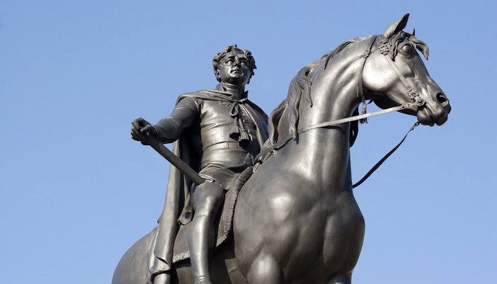 King George IV equestrian statue against a clear blue sky.