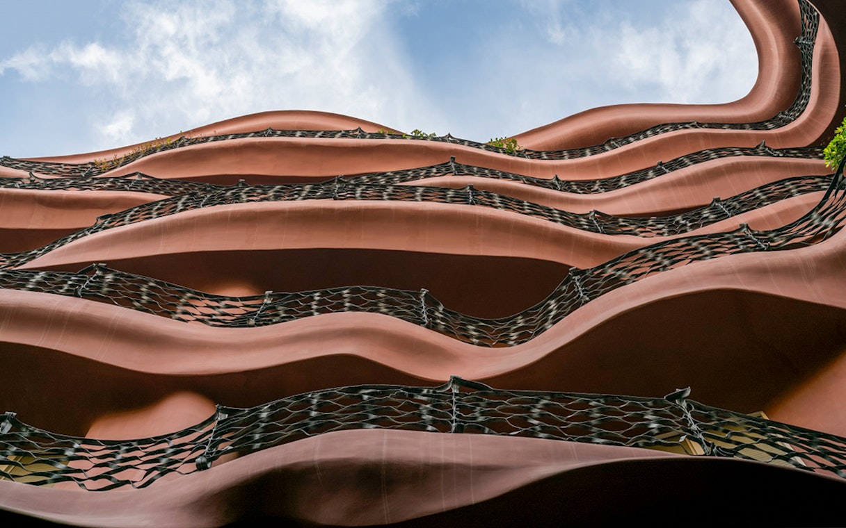 Wavy iron balconies of Casa Mila in Barcelona against a blue sky.