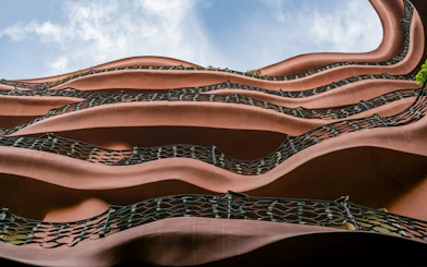 Wavy iron balconies of Casa Mila in Barcelona against a blue sky.
