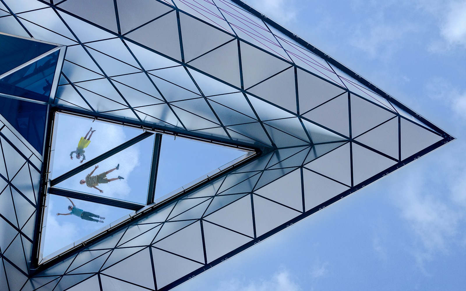 View of people walking on the glass floor at Edge, New York City, from below.