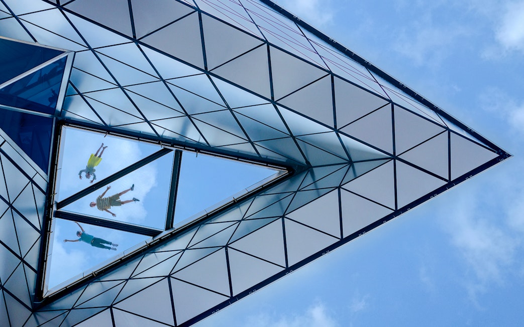View of people walking on the glass floor at Edge, New York City, from below.