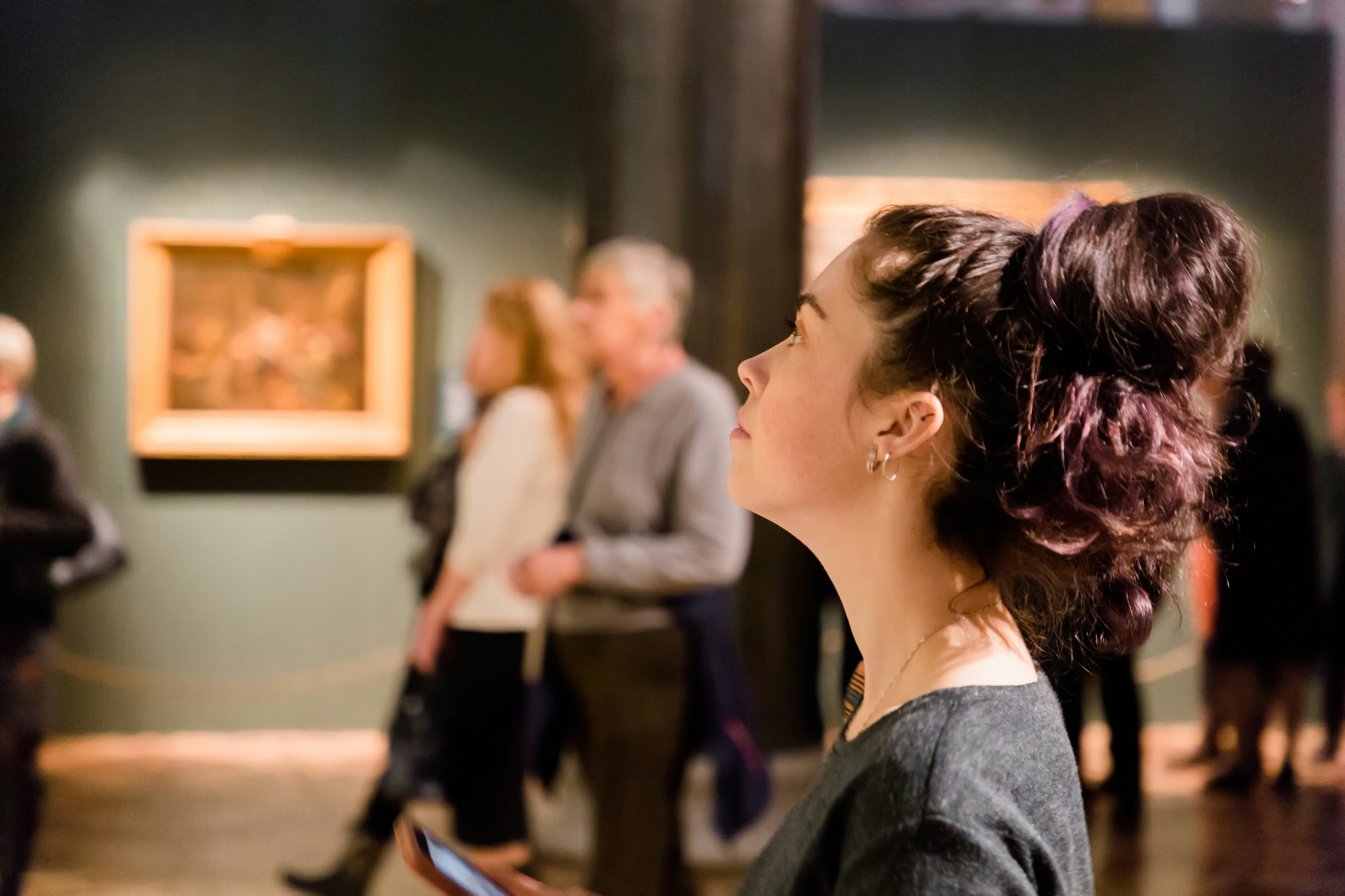 Woman observing artwork at a museum exhibition.