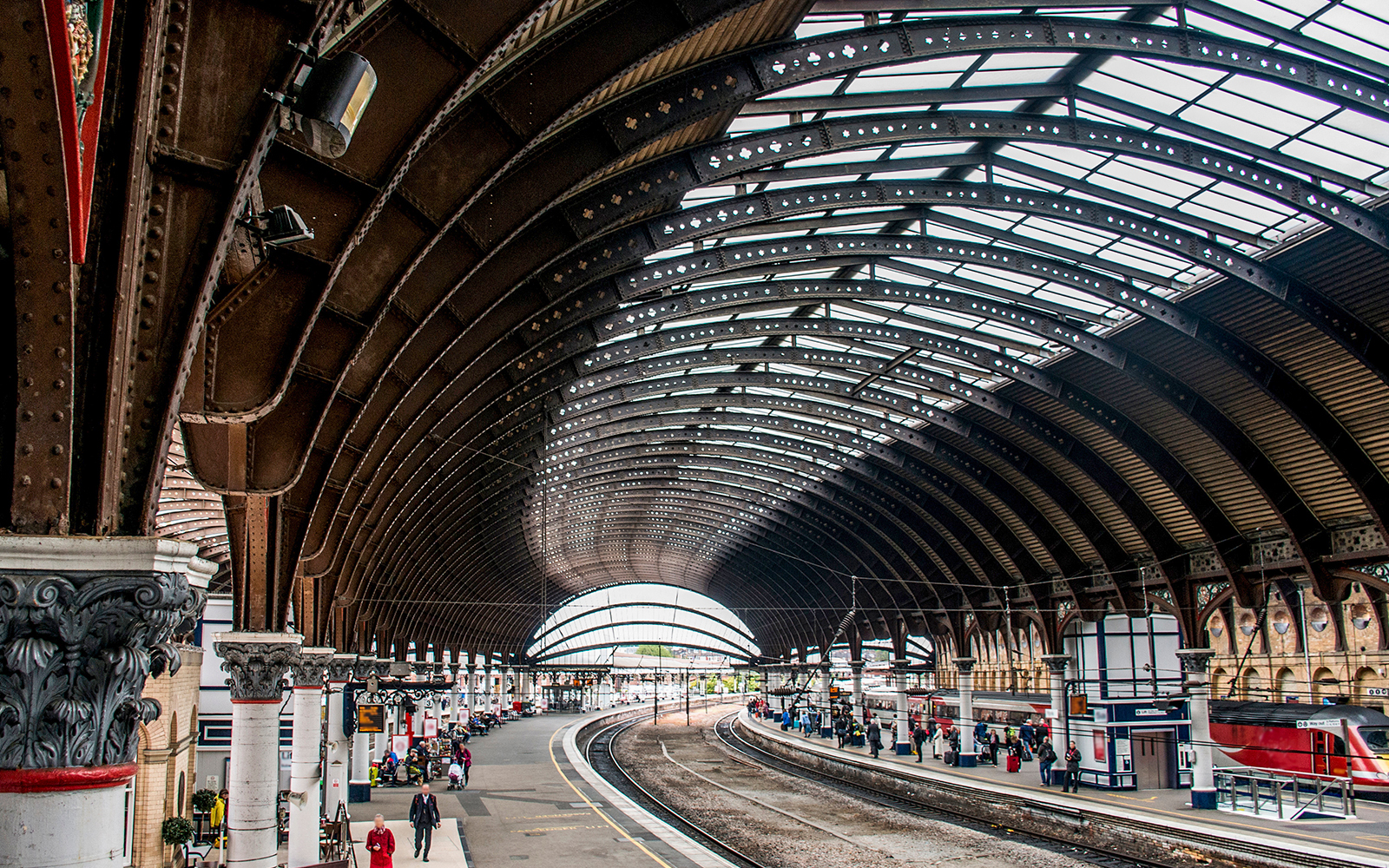York railway station platform with arched roof and waiting passengers.