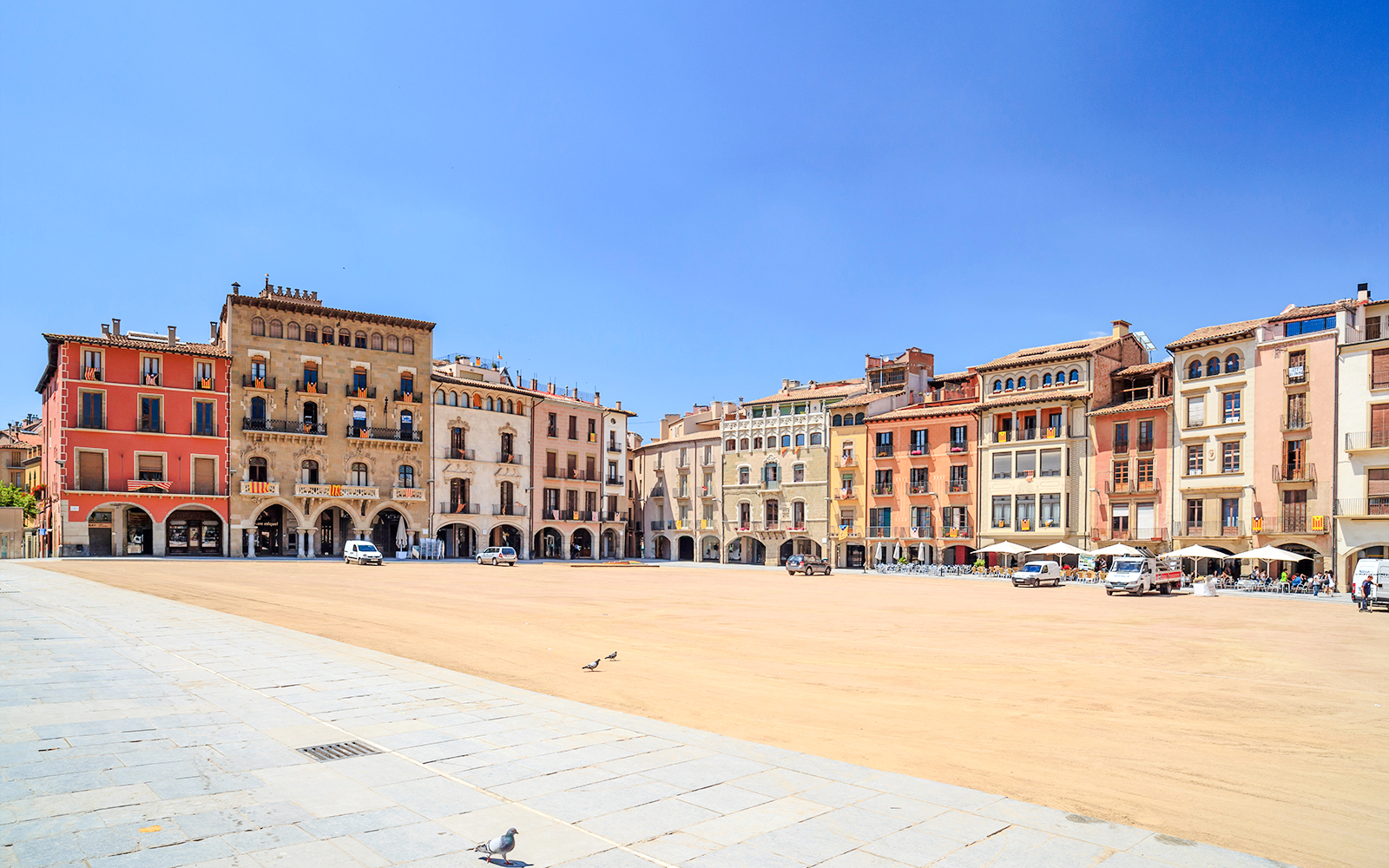 Main square in historic center of Vic, Catalonia, Spain, with colorful buildings and open plaza.
