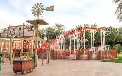 Baz Coaster ride at Al Montazah Parks, featuring red tracks and green cars.