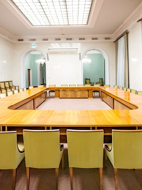Palace of Culture and Science conference room with large wooden table and green chairs.