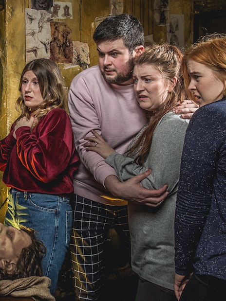 Visitors react to a costumed actor in a dramatic scene at the Edinburgh Dungeon Tour.