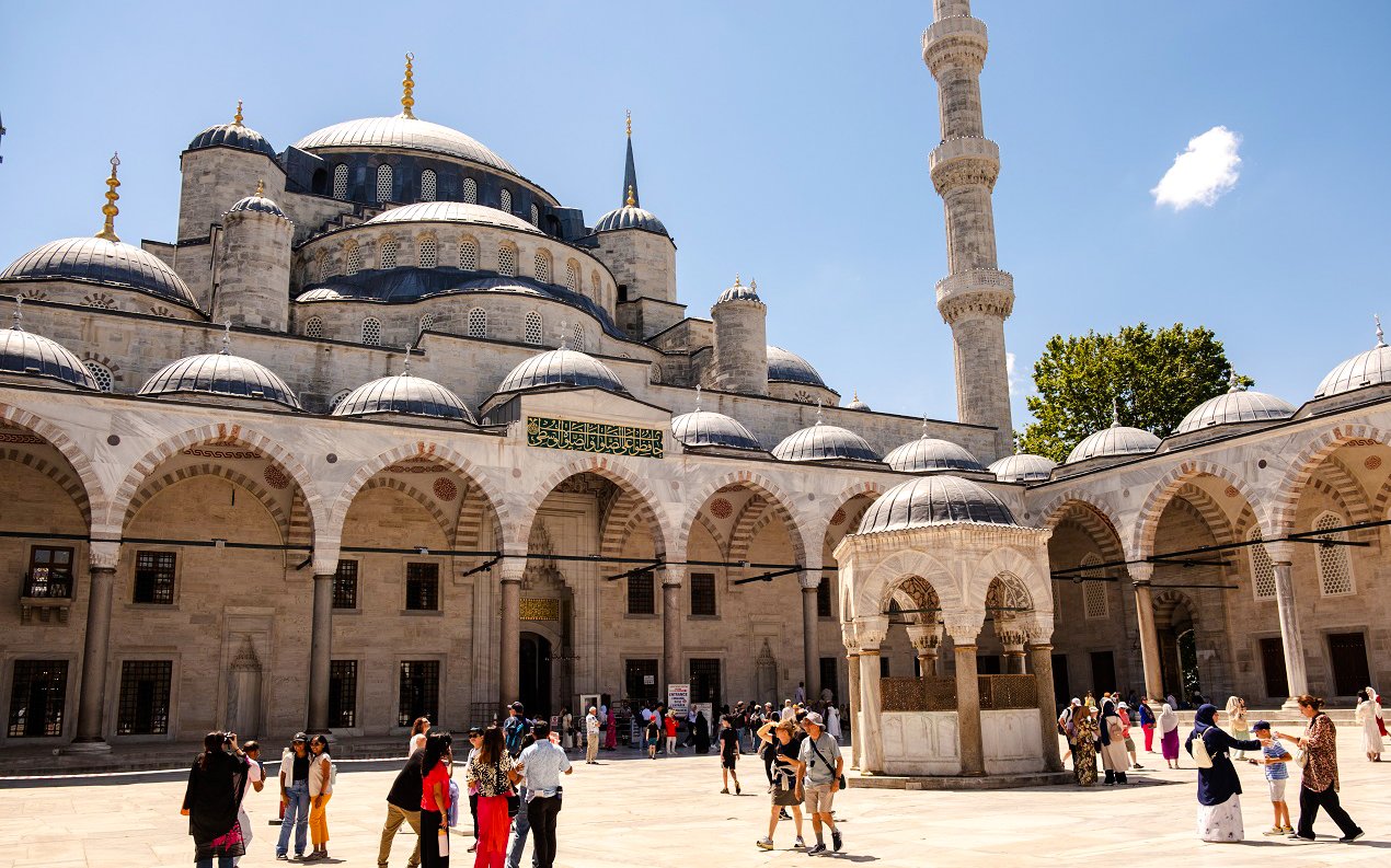 Courtyard of Hagia Sophia with visitors exploring the historic architecture in Istanbul.