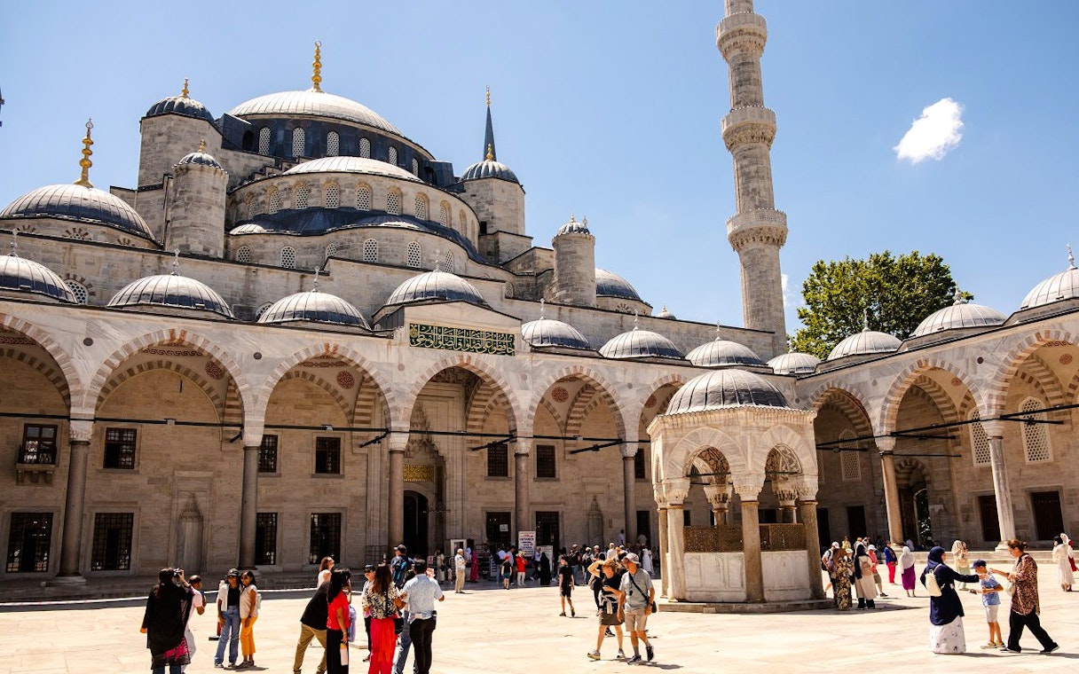 Courtyard of Hagia Sophia with visitors exploring the historic architecture in Istanbul.