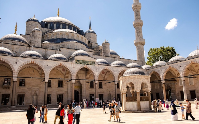 Courtyard of Hagia Sophia with visitors exploring the historic architecture in Istanbul.