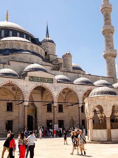 Courtyard of Hagia Sophia with visitors exploring the historic architecture in Istanbul.
