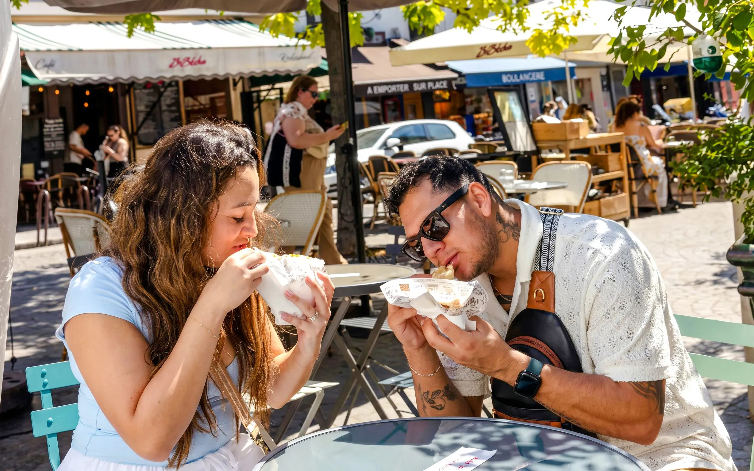 Couple enjoying crepes at an outdoor café during Montmartre Food Tour in Paris.