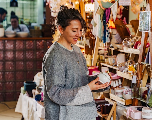 Woman browsing handmade jewelry in a Tenerife market shop.