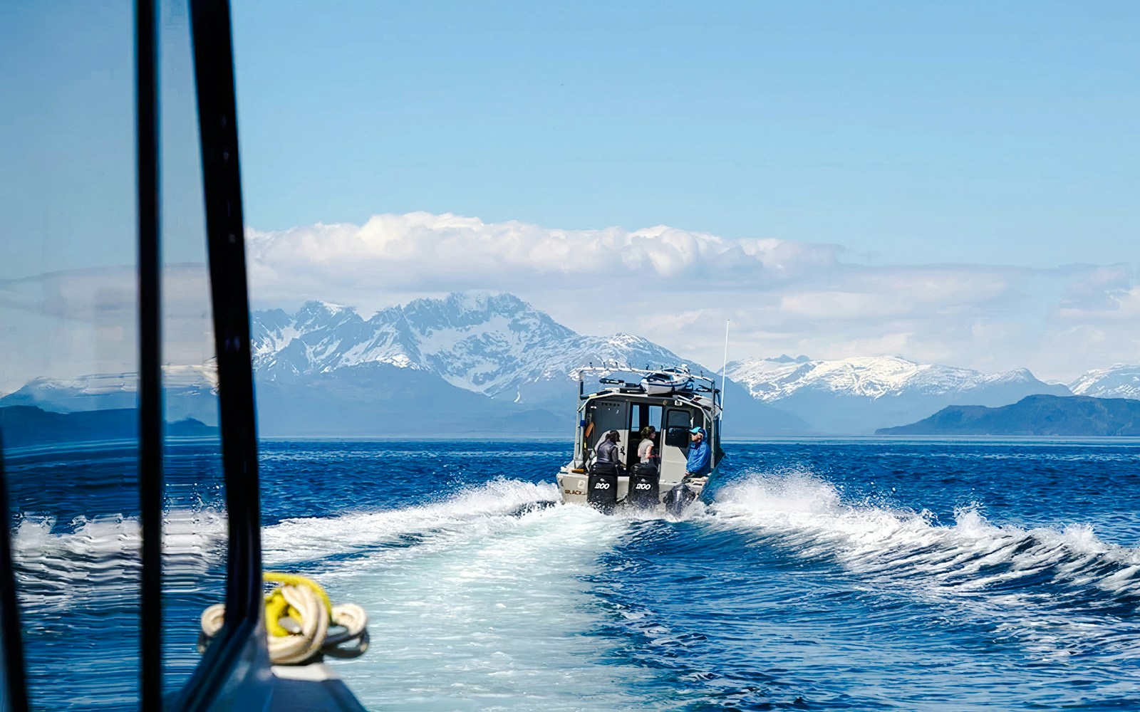 Boat on Alaskan waters with snowy mountains, Juneau.