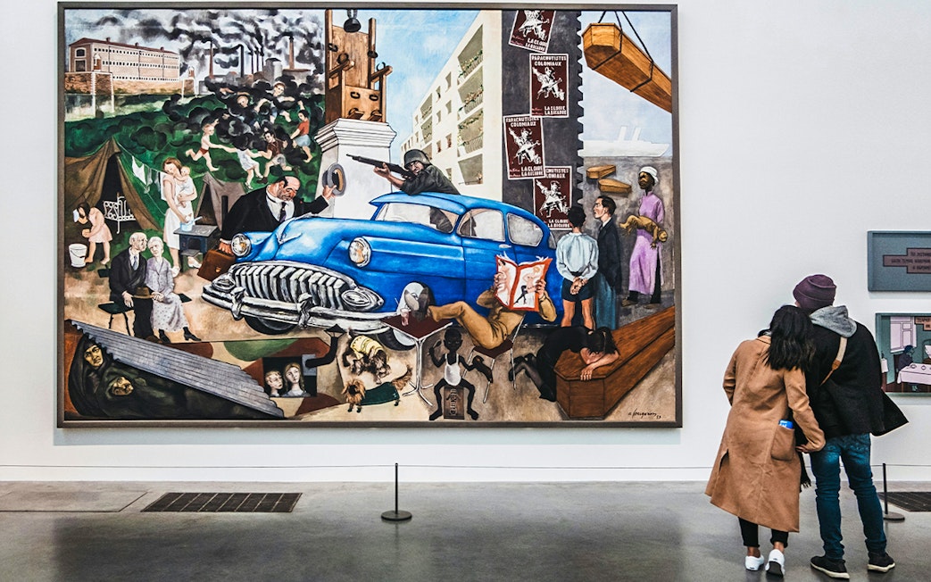 Visitors viewing a large, colorful painting at Tate Modern, London.