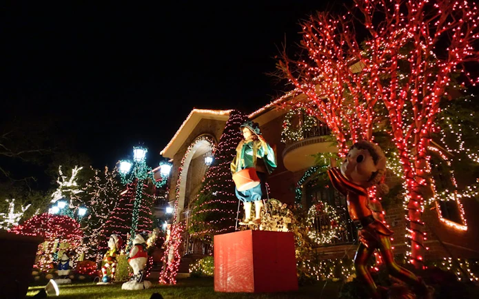 Dyker Heights Christmas lights display with festive decorations and illuminated trees, New York.