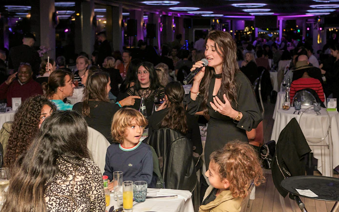 Singer performing for guests on Le Diamant Bleu Seine River dinner cruise.
