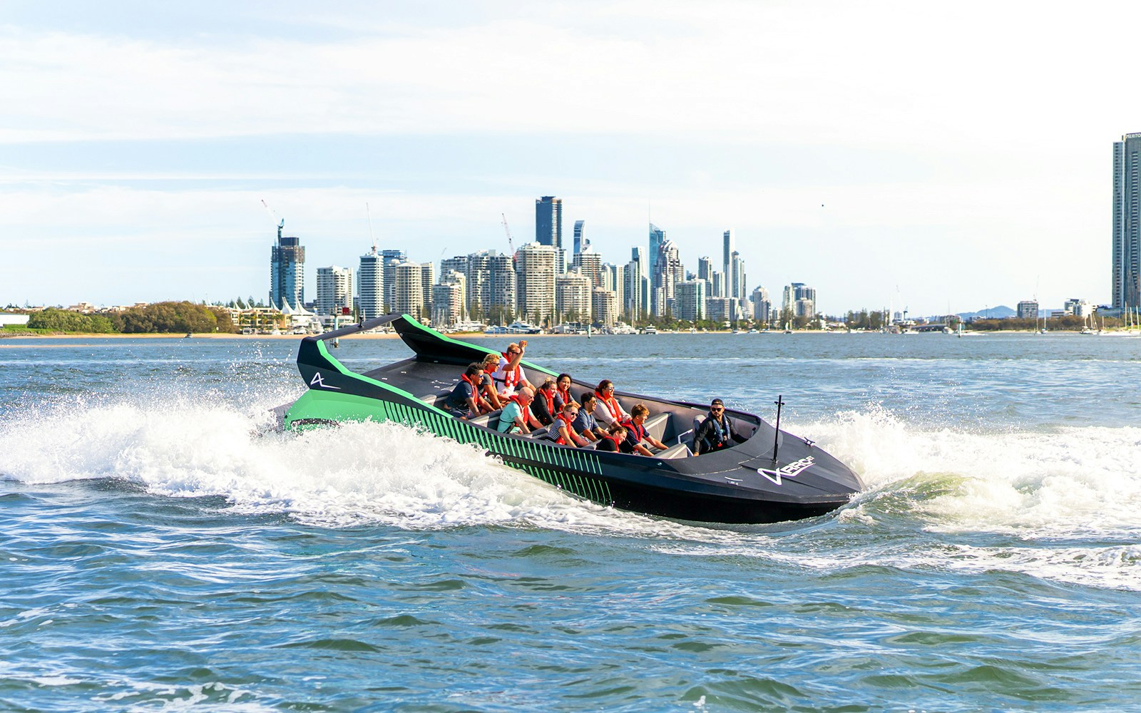 Group enjoying a jet boat ride with Gold Coast skyline in the background, Australia.