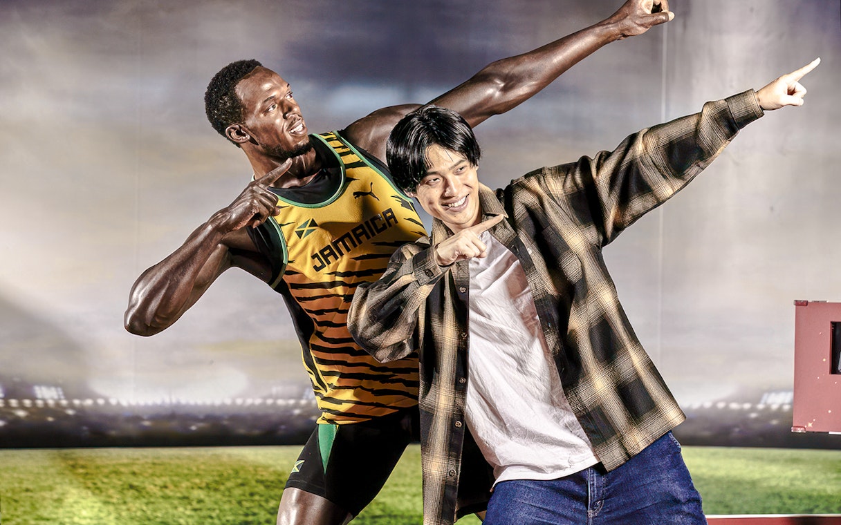 Man posing with wax figure at Madame Tussauds Tokyo.