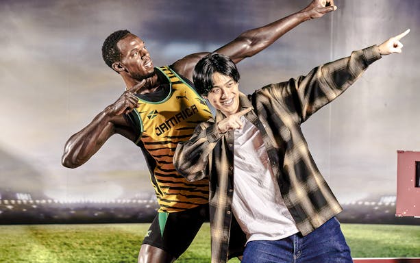 Man posing with wax figure at Madame Tussauds Tokyo.