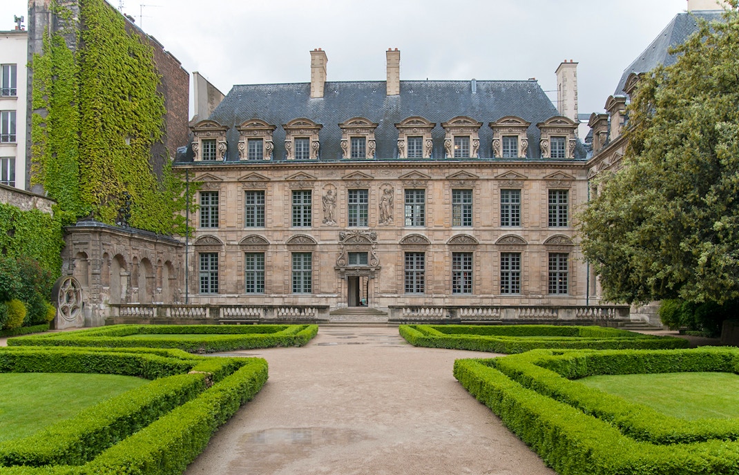 Courtyard of Hôtel de Sully in Paris with historic architecture and manicured garden.