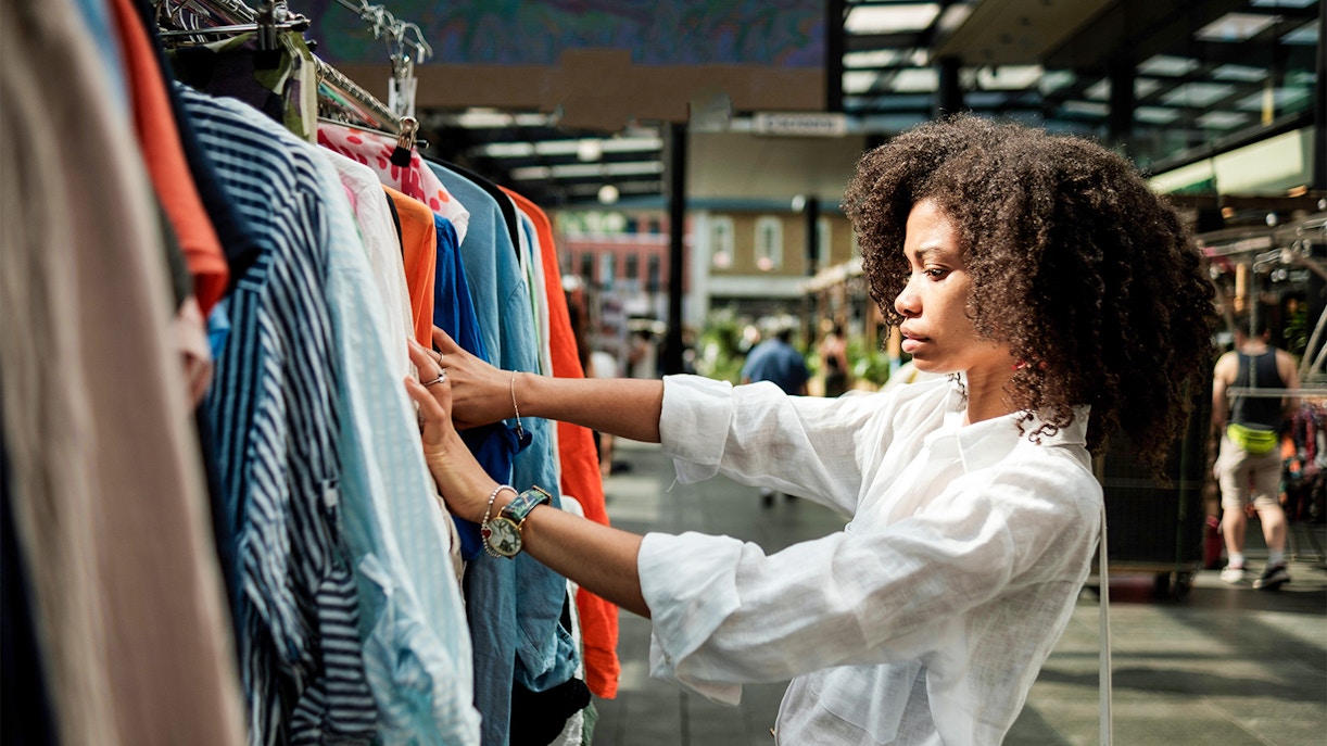 Shopping at a London market, browsing colorful clothes on a rack.