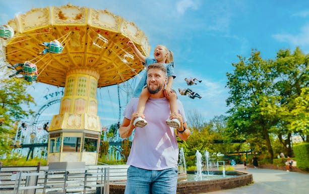 Father and daughter enjoying carousel ride at Bobbejaanland theme park.