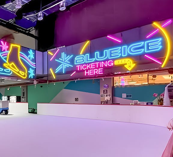Neon signs at Blue Ice Skating Rink, 163 Retail Park, with ticketing area.