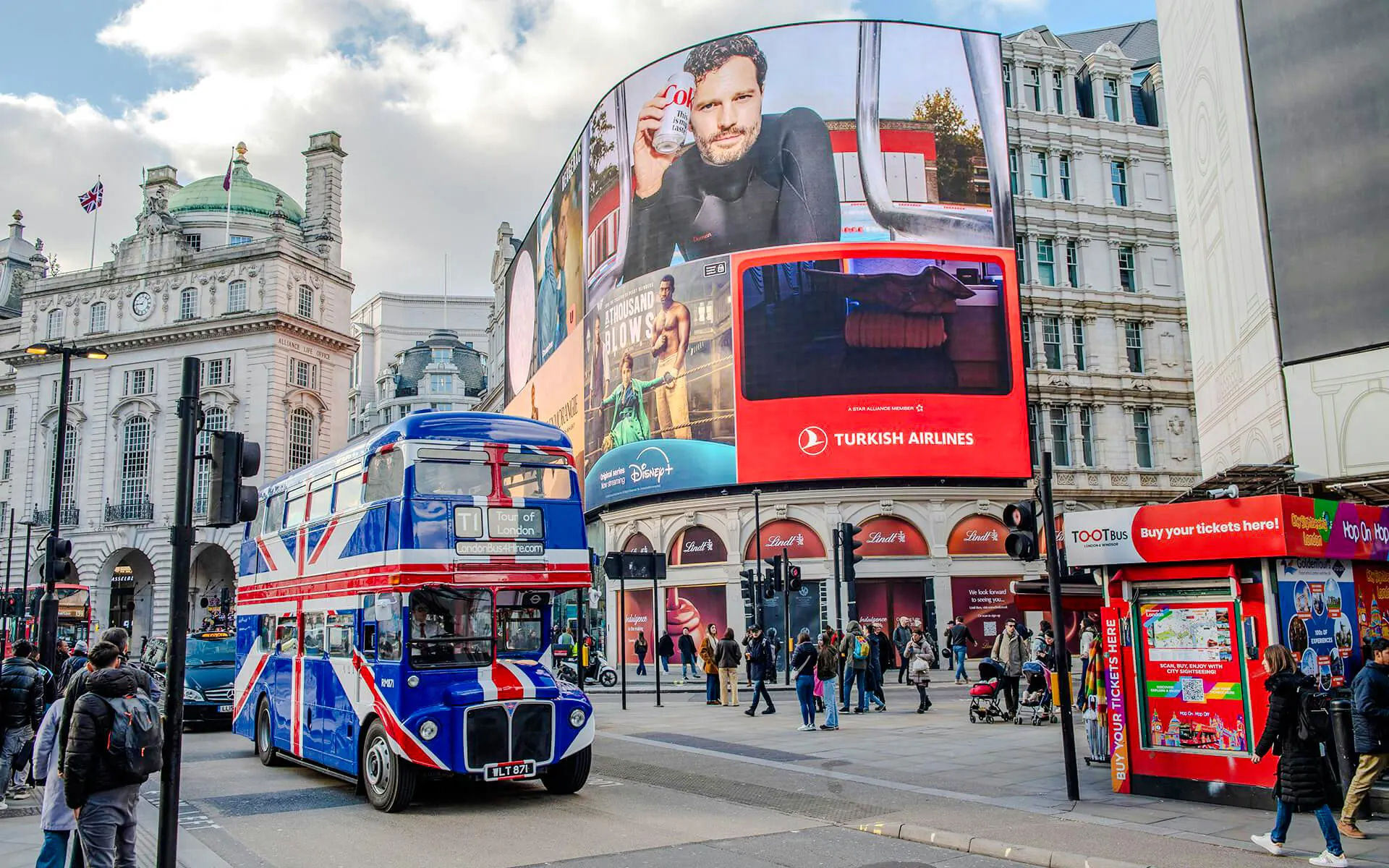 Double-decker bus with Union Jack design at Piccadilly Circus, London.