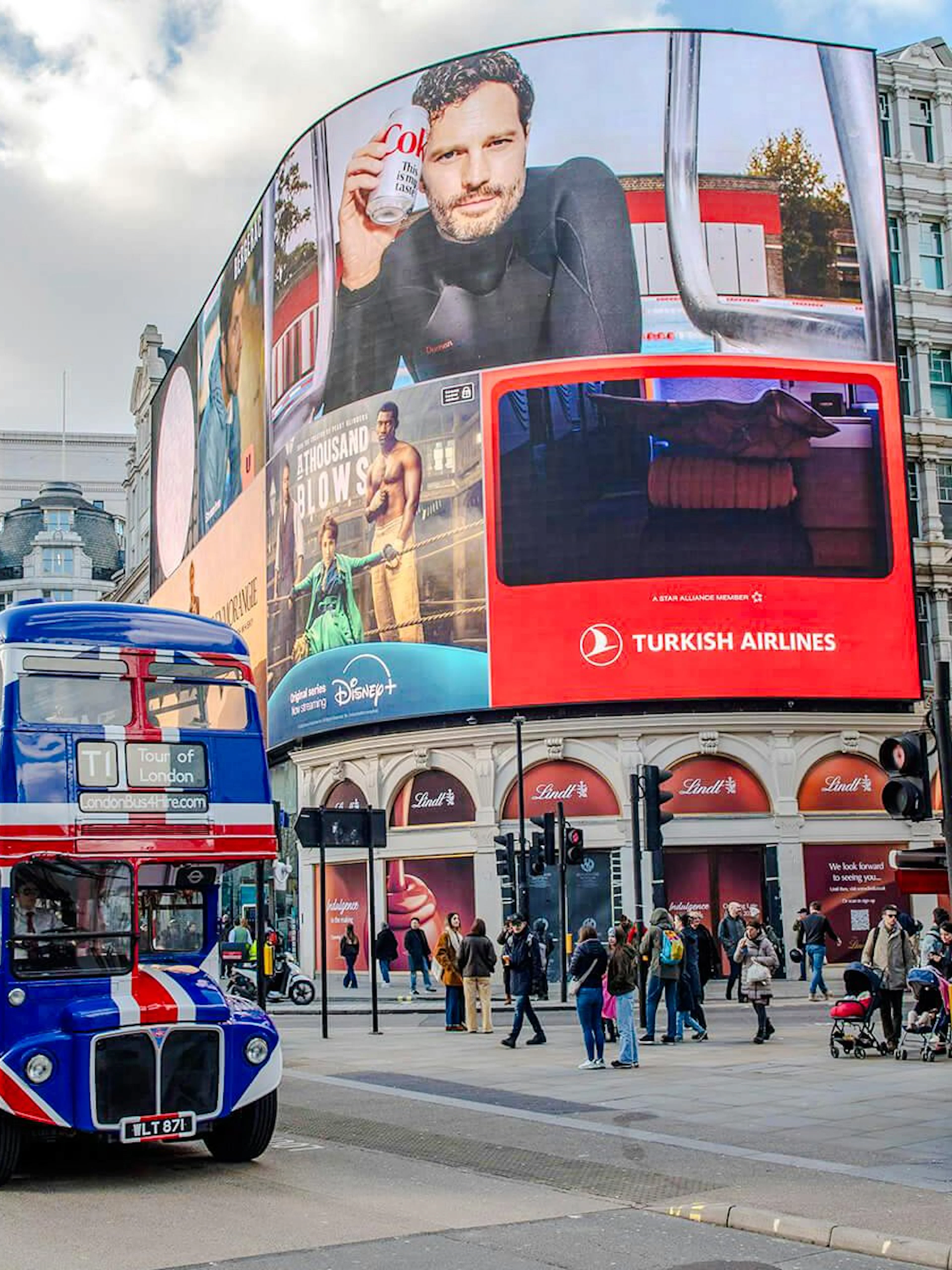 Double-decker bus with Union Jack design at Piccadilly Circus, London.