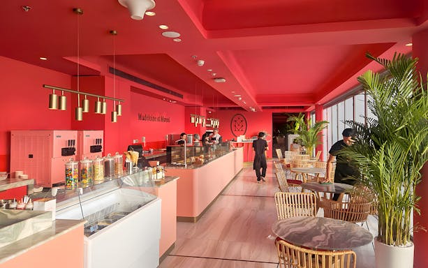 Interior of Madeleine et Marcel café at The View, Palm Jumeirah, with seating and dessert counter.