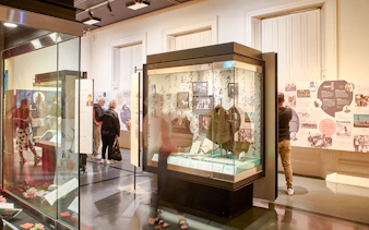 Visitors exploring exhibits at the Immigration Museum guided highlights tour.