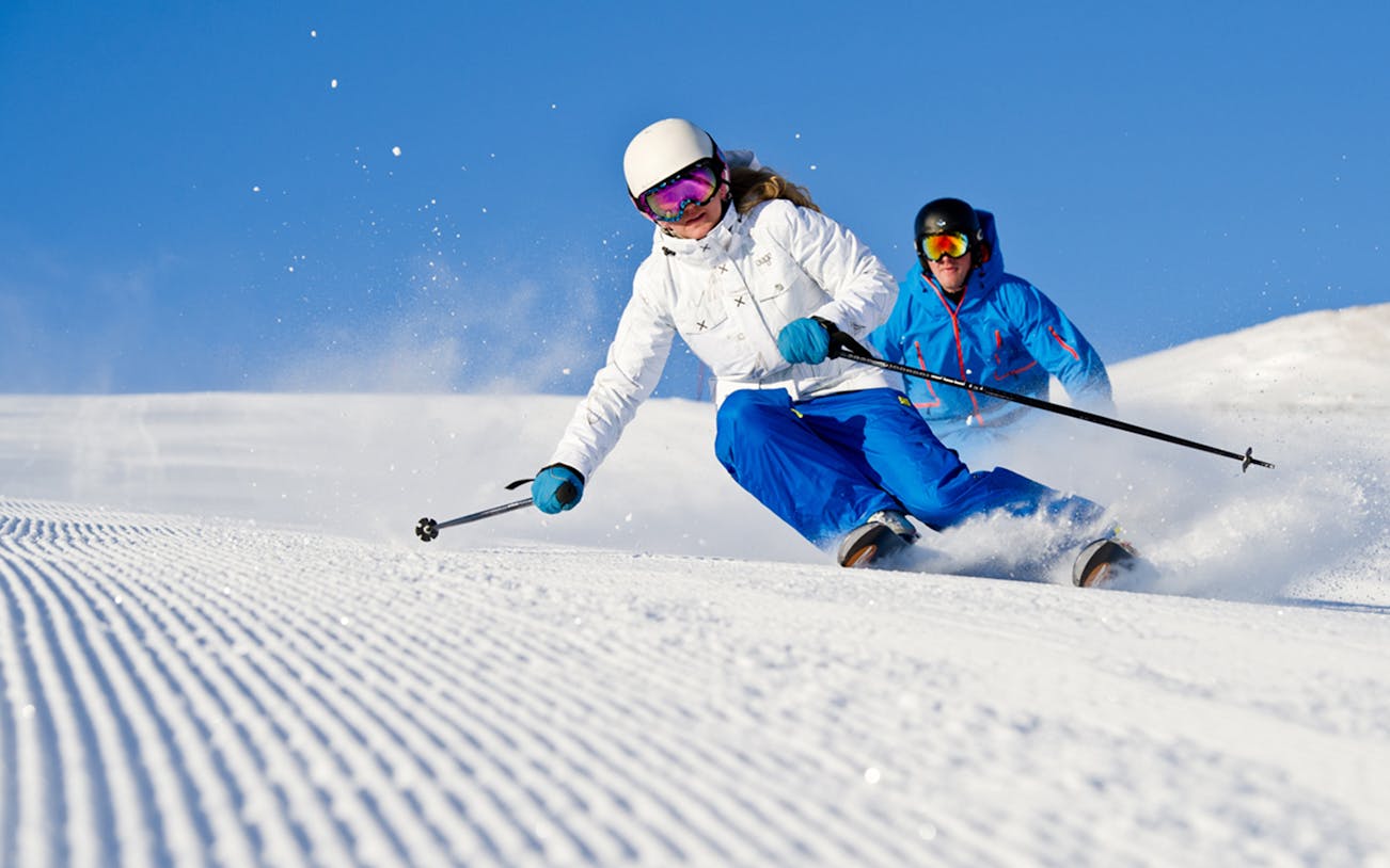 Skiers descending a snowy slope near Chochołów Thermal Baths, Krakow tour.