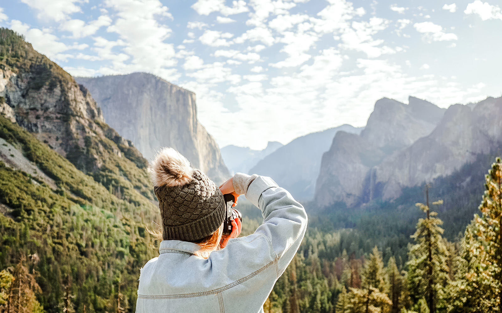 Person photographing Yosemite Valley landscape on a day tour from San Francisco.