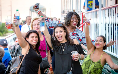 Group enjoying drinks on the deck of the CITY of NEW ORLEANS riverboat during a jazz cruise in New Orleans.