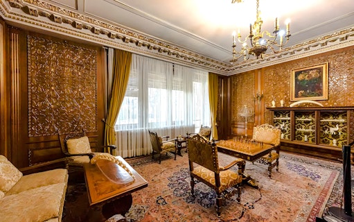 Interior of Ceaușescu Mansion in Bucharest with ornate wood paneling and vintage furniture.