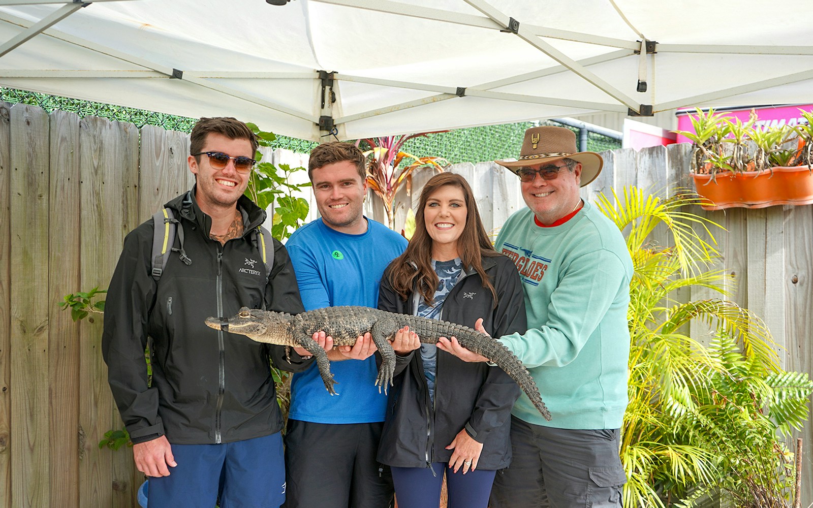 Guests holding a small alligator at Everglades Holiday Park animal encounter.