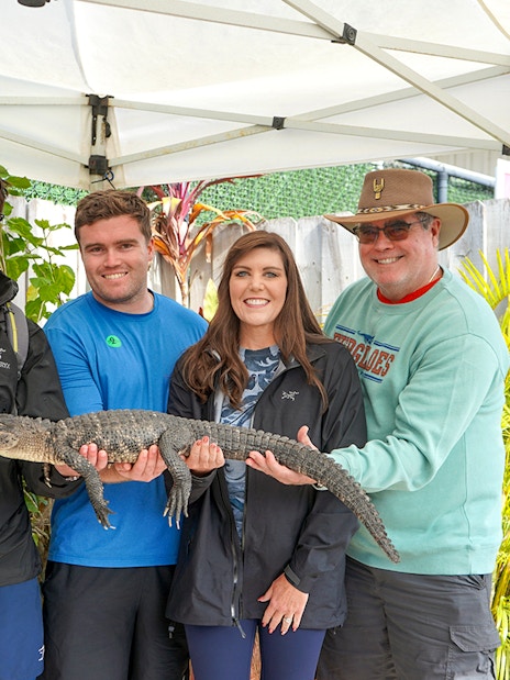 Guests holding a small alligator at Everglades Holiday Park animal encounter.